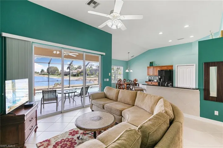 Living room featuring ceiling fan, recessed lighting, vaulted ceiling, and light tile patterned floors