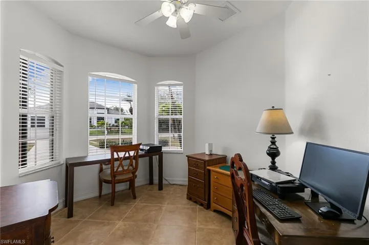 Office space with a ceiling fan and light tile patterned floors