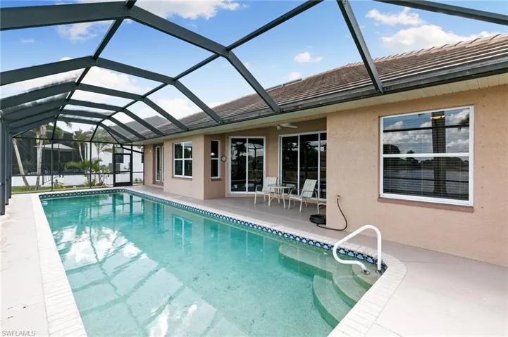Outdoor pool featuring a sunroom, a patio area, and a lanai