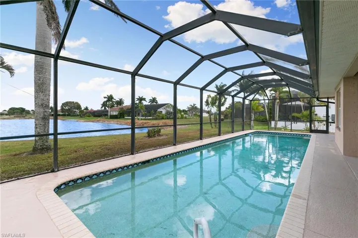 Outdoor pool featuring a sunroom, a lawn, a lanai, a water view, and a patio area
