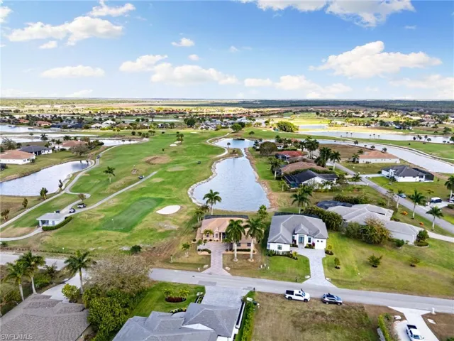 Aerial perspective of suburban area with a large body of water and a local golf course