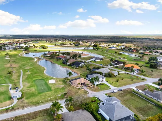 Aerial view of residential area with a local golf course and a large body of water