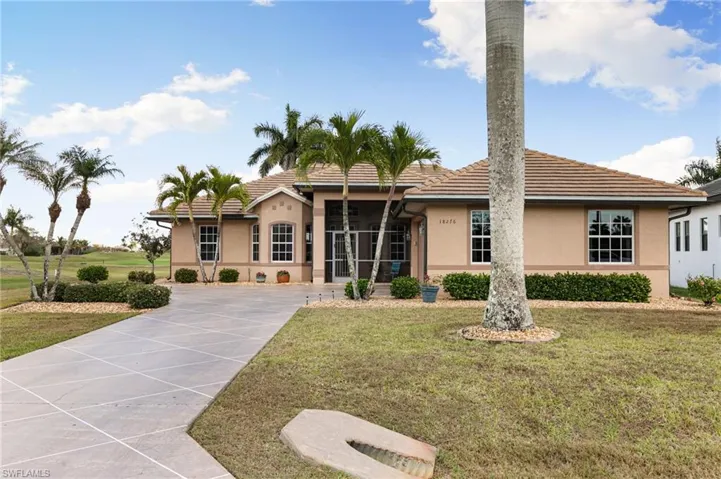 Ranch-style house featuring a front yard, stucco siding, driveway, and a tile roof