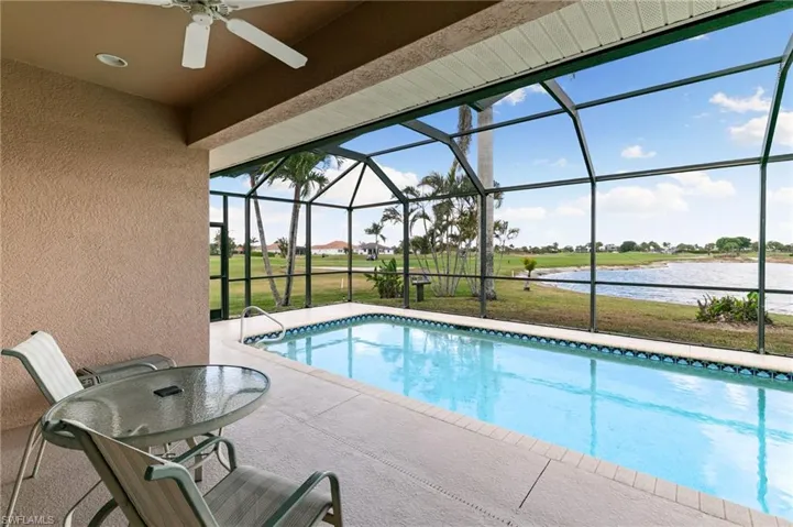 Swimming pool featuring a sunroom, a yard, a lanai, and a water view