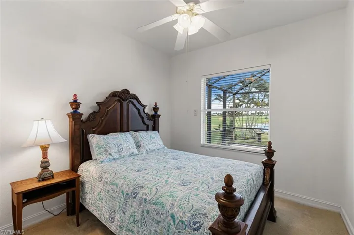 Bedroom with light carpet and a ceiling fan