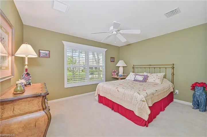“Comfortable guest bedroom with large window and neutral finishes.”