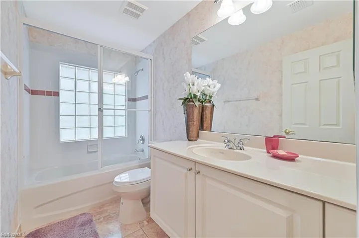 “Immaculate guest bath with neutral tile and a clean, modern feel.”