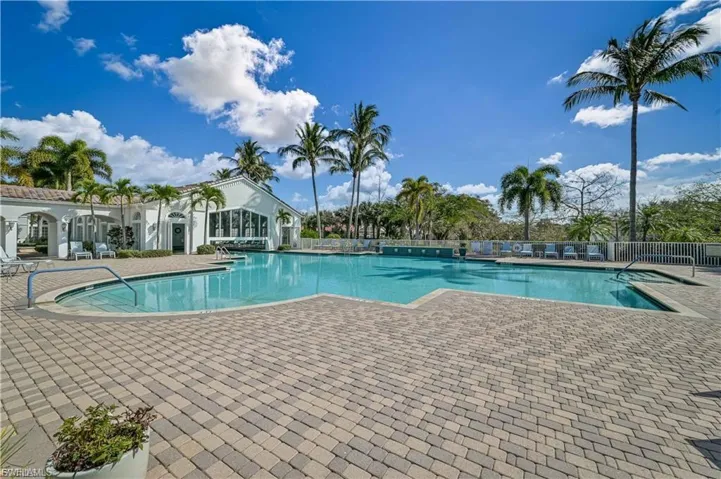 “Resort-style outdoor pool surrounded by palm trees and plenty of lounge space.”
