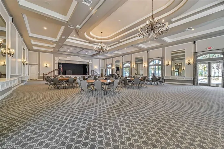 “Grand clubhouse event hall with chandeliers and stage — perfect for community gatherings.”