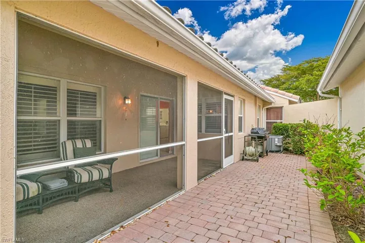 “Low-maintenance exterior with extended paver patio and lush tropical surroundings.”