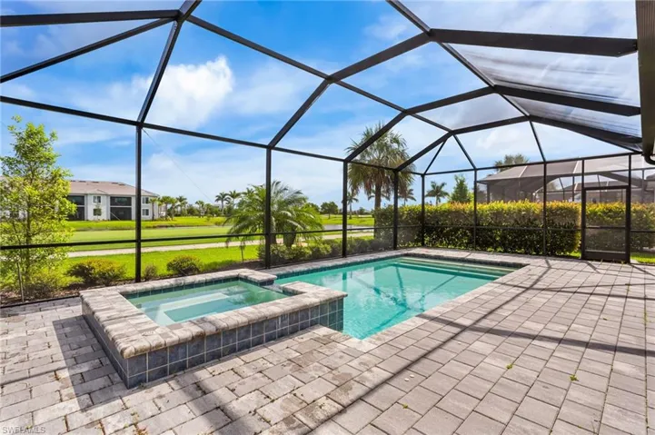 View of pool with a pool with connected hot tub, a patio, and a lanai