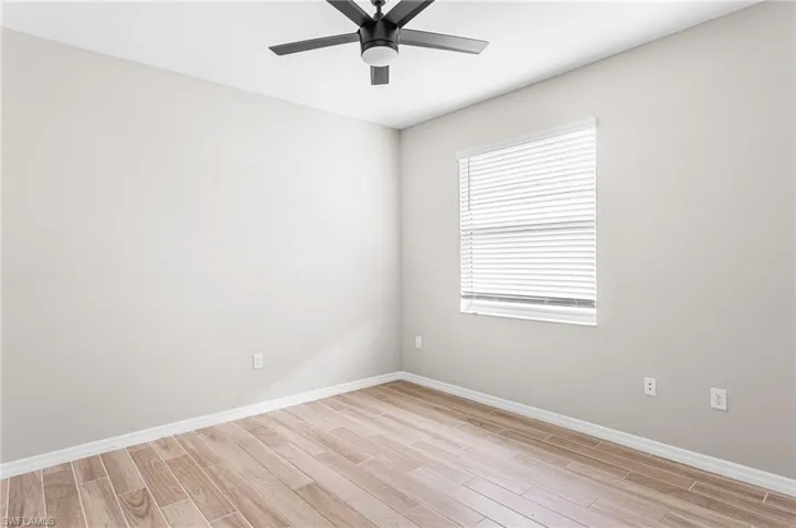Unfurnished room featuring light wood-type flooring and ceiling fan