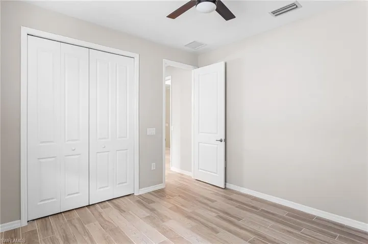 Unfurnished bedroom with light wood-type flooring, a closet, and ceiling fan