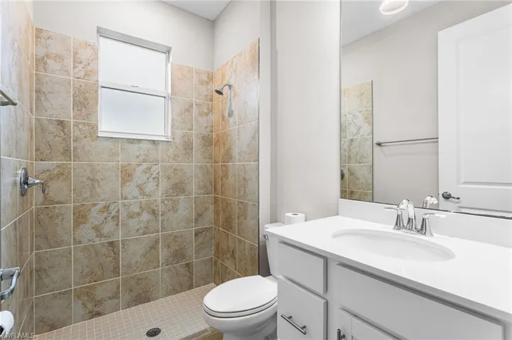 Bathroom featuring vanity and tiled shower