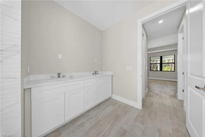 Dual vanity with white cabinetry and integrated sinks