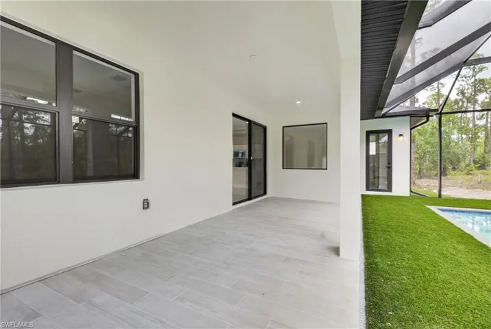 Expansive covered patio featuring light-toned tile flooring and recessed lighting