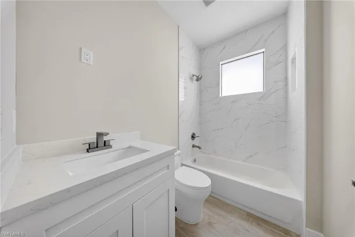 Bathroom featuring a white vanity with an integrated rectangular sink and a matte black faucet