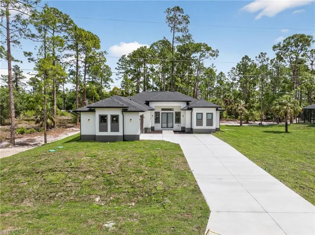 Modern single-story residence featuring a dark shingle roof, white stucco exterior, and a two-car garage