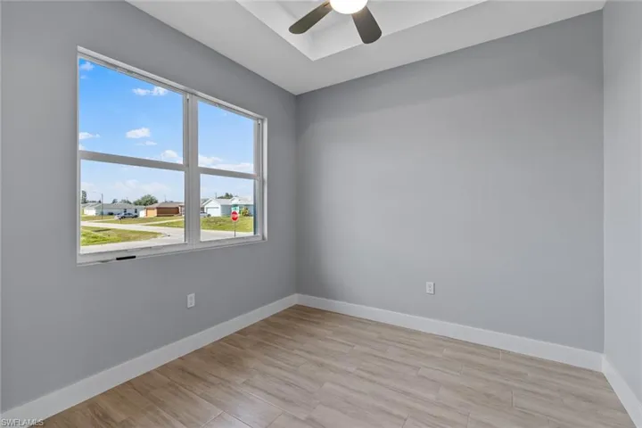 Spare room with light wood-style floors, ceiling fan, and baseboards