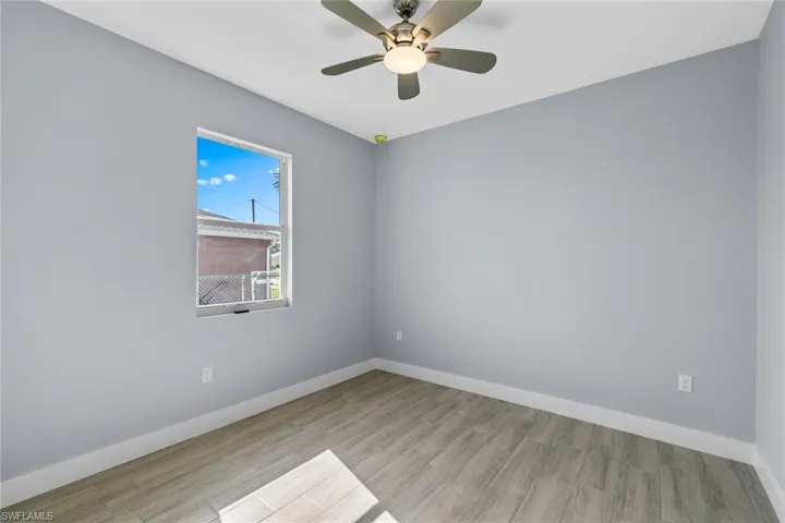 Empty room with baseboards, ceiling fan, and wood finished floors