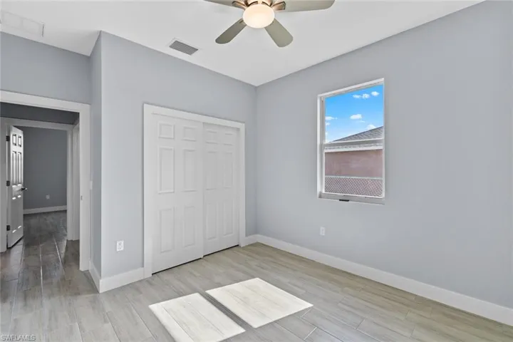 Unfurnished bedroom featuring visible vents, baseboards, light wood-type flooring, and a closet
