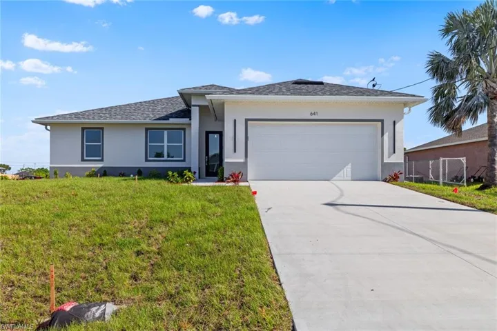 View of front of property featuring an attached garage, concrete driveway, stucco siding, and a front lawn