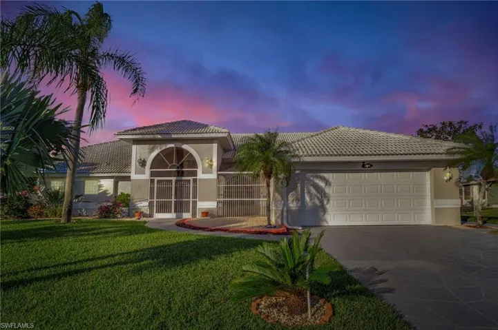 Mediterranean / spanish-style house with a yard and a garage