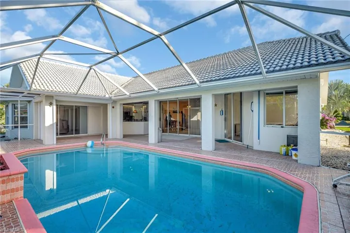 View of swimming pool featuring a patio and glass enclosure