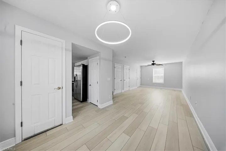 Unfurnished living room with wood tiled floors and a ceiling fan