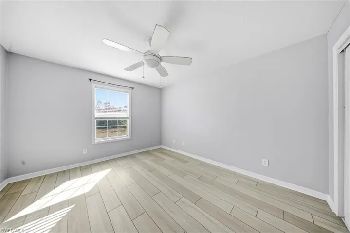 Spare room with wood finish floors and ceiling fan