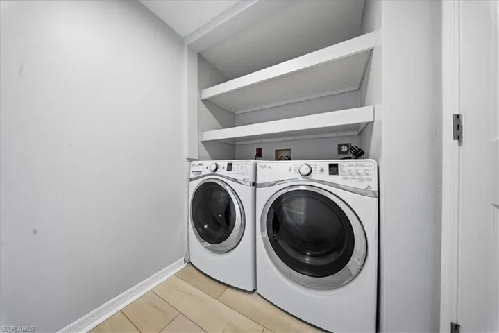 Laundry area with light wood-type flooring and independent washer and dryer