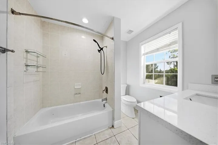Bathroom featuring vanity, tub / shower combination, and light tile patterned floors