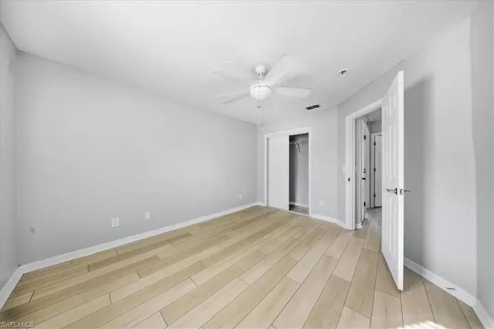 Unfurnished bedroom with a closet, light wood finished floors, and a ceiling fan