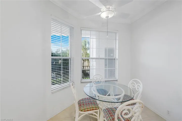 Dining area featuring crown molding, light tile patterned flooring, and a ceiling fan