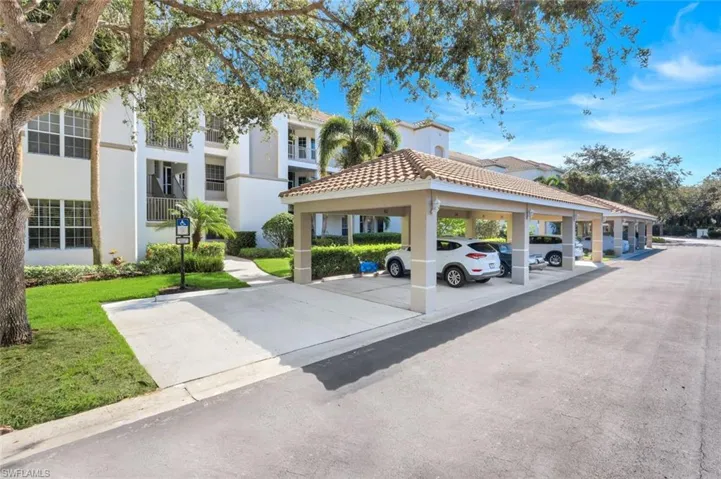 View of property's community with covered parking and a lawn