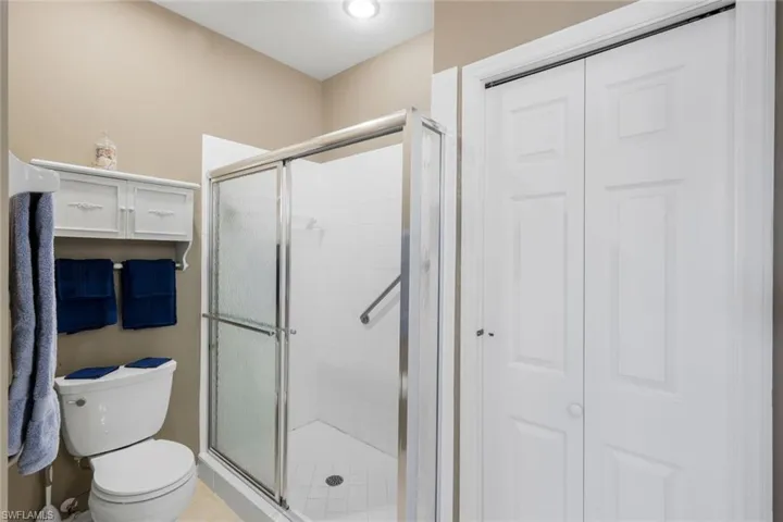 Full bathroom featuring a closet, a shower stall, light tile patterned floors, and recessed lighting