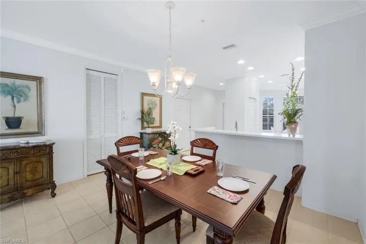 Dining area with crown molding, light tile patterned floors, a chandelier, and recessed lighting