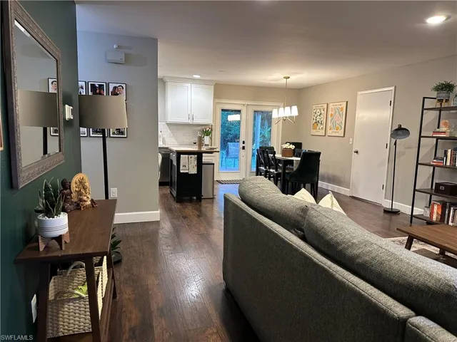 Living area with dark wood-style flooring, baseboards, and recessed lighting
