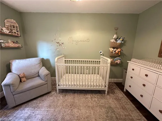 Bedroom with baseboards and a crib