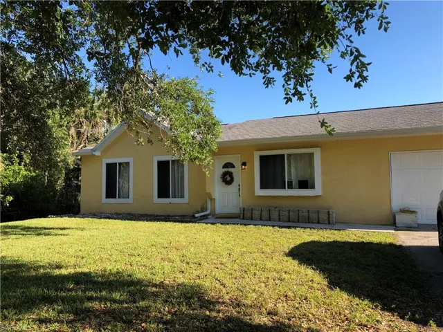 Ranch-style house with a front yard and stucco siding