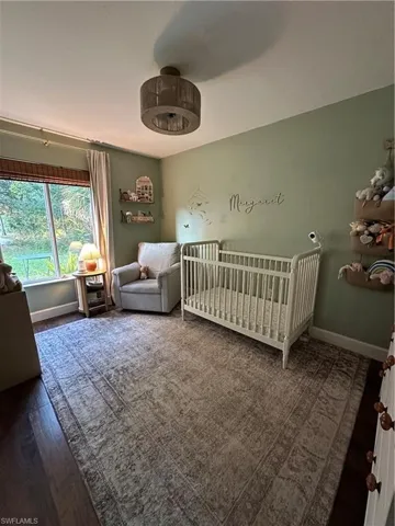 Bedroom featuring baseboards and a nursery area