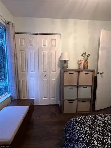 Bedroom with a closet and dark wood-style floors