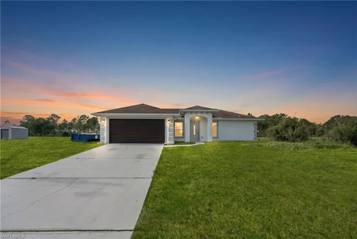 Single-story residence featuring a neutral exterior, a dark brown garage door, and a concrete driveway