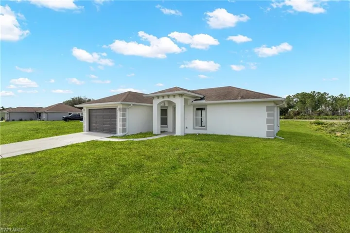 Contemporary white stucco exterior with a prominent two-car garage, a covered entry, and dark-framed windows