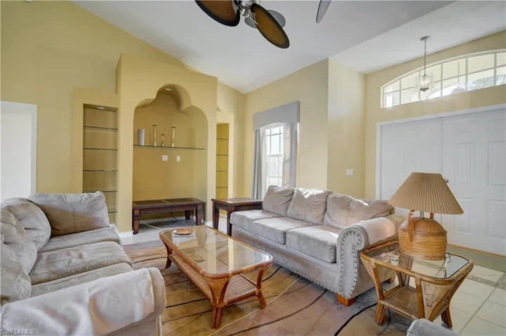 Open living area with vaulted ceiling and ceiling fan