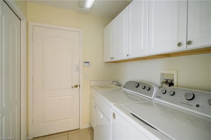Laundry area with washer, dryer, deep sink, cabinets and utility/pantry closet.
