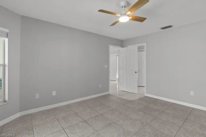 Master bedroom featuring a ceiling fan and light tile patterned flooring