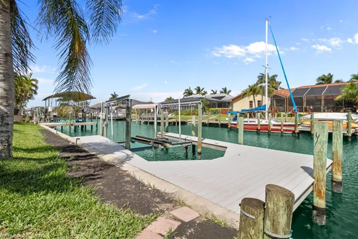 Dock area featuring boat lift, a water view, and a residential view