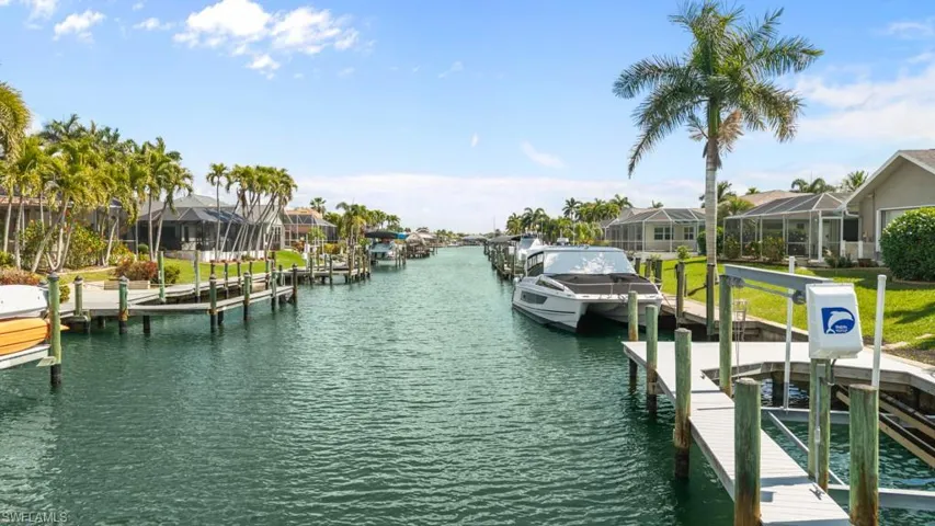 Dock with a water view, boat lift, and a residential view