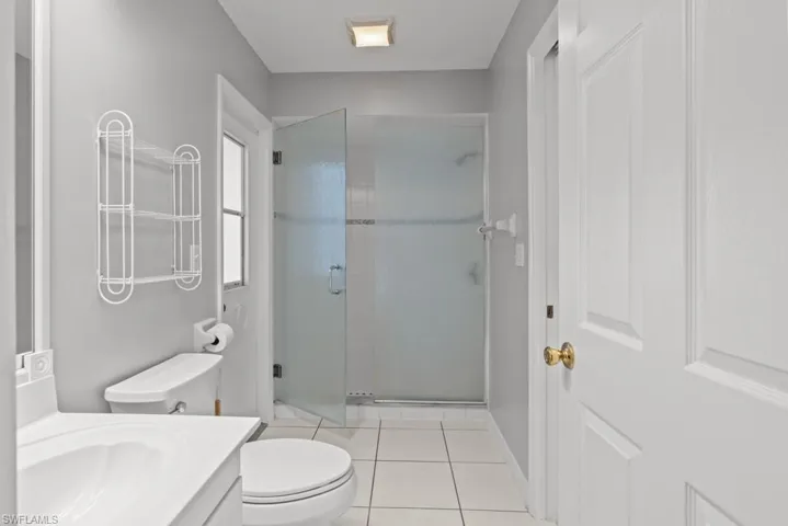 Full bathroom with vanity, a shower stall, and light tile patterned floors